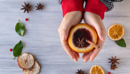 German tradition winter Christmas market new year holidays festival drink tea punch Gluhwein Mulled hot warm red Wine in apple orange mug spices citrus aromatic cinnamon star anise woman hand hold
