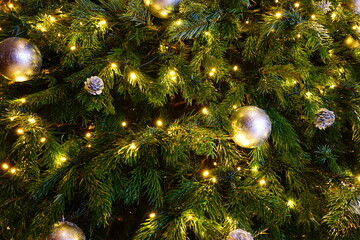 Obraz na płótnie Canvas A Christmas tree decorated with golden holidays ornaments and fabric bows