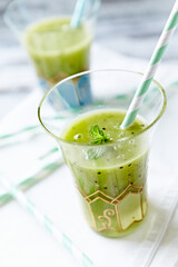 Green smoothie topped with chia seeds on bright wooden background. Close up.