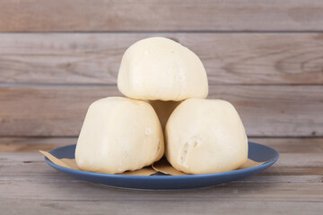A pile of freshly made big white steamed buns on a plate