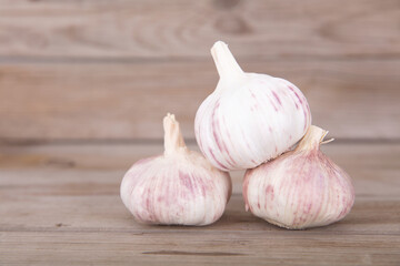 Three heads of fresh garlic on the wooden table