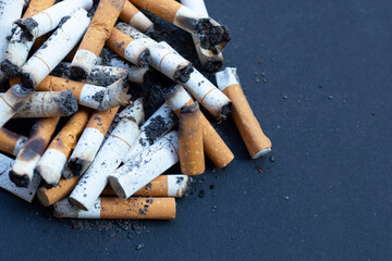 Cigarette butts on dark background.