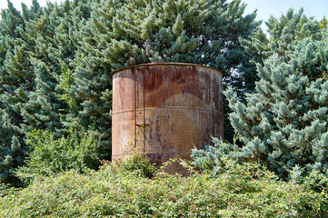 Fototapeta na wymiar old rusty barrel in the trees