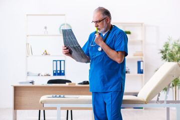 Old male doctor radiologist working in the hospital