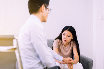 Depression asian woman sitting on sofa with psychologist at hospital,Female under a lot of pressure,World mental health day,Suicide prevention concept