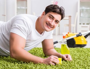 Young husband man cleaning floor at home