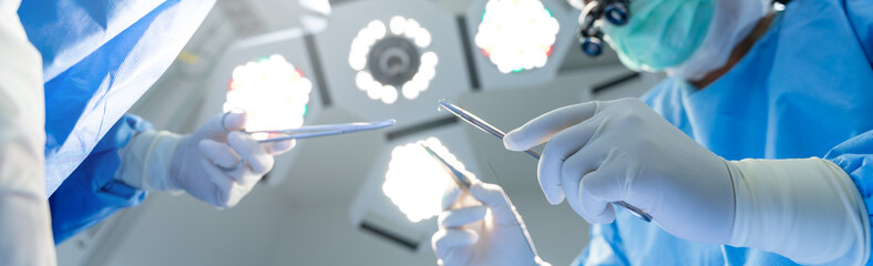 Close-up of gloved hands holding surgical equipment at the operating room, For Medical surgery banner Background - obrazy, fototapety, plakaty