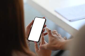 Close up view of two female are reading information on cell mobile phone during in office setting.