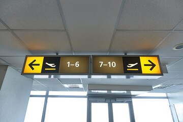 Airport departure gate numbers and directions on a sign