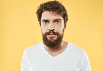Obraz premium A man with a beard and mustache on a yellow background and a white T-shirt