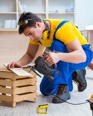 Repairman carpenter cutting sawing a wooden board with an electr