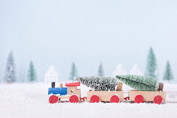 Christmas tree on toy train was running through the snow in the field of natural Landscape background