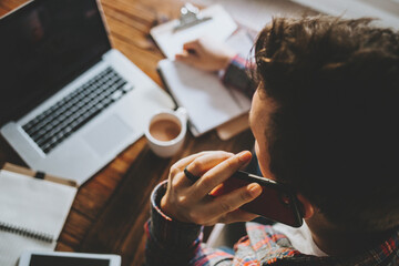 Fototapeta premium Man Working from Home on Laptop in Kitchen