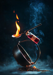 Cauldron, fire potion and a spoon with flame in a balancing composition with smoke, fantasy book cover