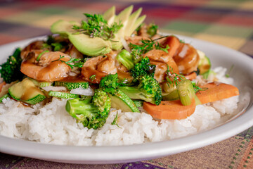 Delicious shrimp teriyaki with broccoli, pumpkin, carrot and rice in oyster sauce on a white plate.