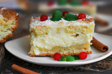 A piece of shortbread pie on sour cream with a creamy curd layer.The cake is decorated with ripe red cranberries