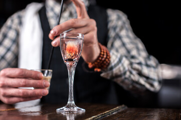 Portrait of bartender creates a cocktail in cocktail bars