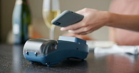 Woman pays with mobile phone with pos machine
