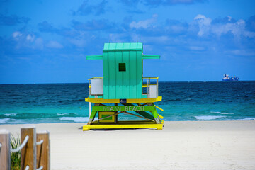 Miami Beach with lifeguard tower and coastline with colorful cloud and blue sky. Sunny summer day,...