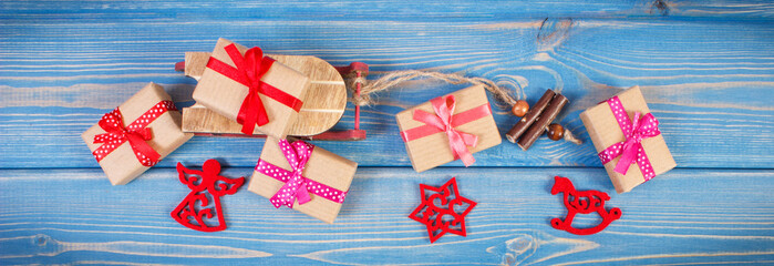 Fototapeta na wymiar Wooden sled and wrapped gifts with ribbons for Christmas or other celebration