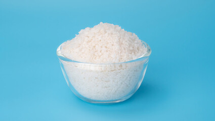 White flower of salt in a bowl on a blue background.