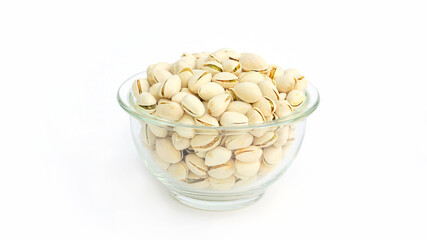 Pistachio nuts in a bowl on a white background.
