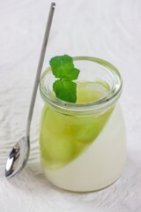 Puding buah melon. Melon fruit pudding in a glass on a white background.