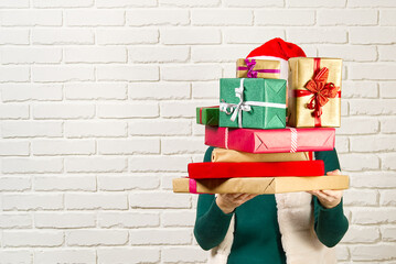 unrecognizable woman holding many christmas gifts. woman holding a lot of boxes with gifts