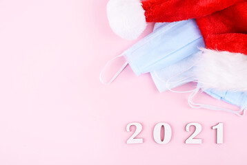 Medical protective mask on a pink background.Santas cup. New Year and coronavirus concept.The inscription of a HEALTHY NEW YEAR.