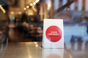 Close-up closed temporarily  sign in the window of a restaurant  displaying the message 