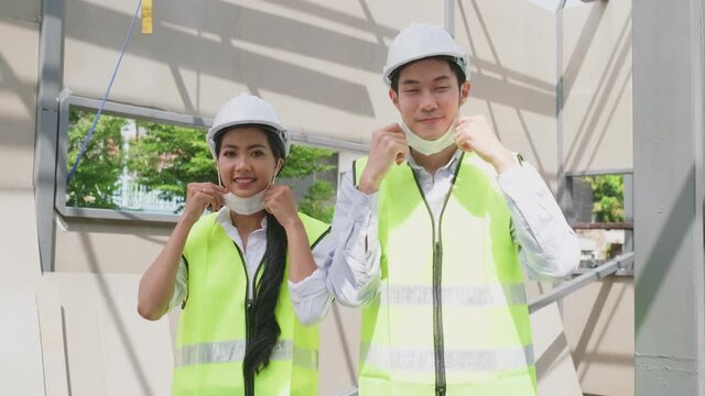 Asian young engineer man and woman wearing PPE, Protective face mask.	