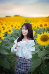 Happy enjoy summer girl in sunflower field in spring. Asian young woman joyful and smiling at sunset time