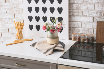 Beautiful vase with bouquet of flowers in kitchen