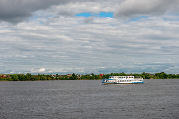 A pleasure boat sails along the Volga River on a summer day