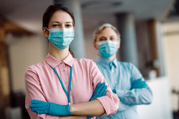 Confident female business leader with protective face mask looking at camera.