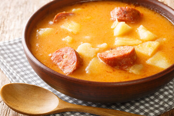 Krumplileves Hungarian potato soup with sausages and sour cream close-up in a plate on the table. horizontal