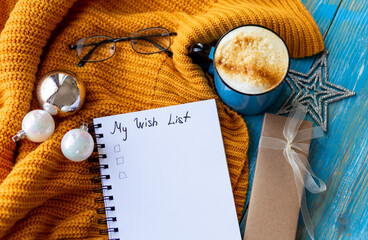 Flat lay New Year decorations and blank white spiral notebook with to-do list framed with cozy...