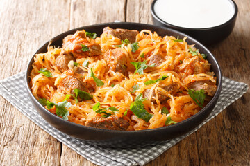 Homemade Szegedin goulash sauerkraut stew with pork, onions and paprika close-up in a plate on the table. horizontal