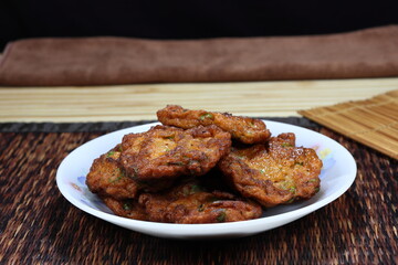 Pile of deep fried Thai Food Curried fish cake on the plate. Famous traditional baked chilly paste ball in Asia restaurant. 