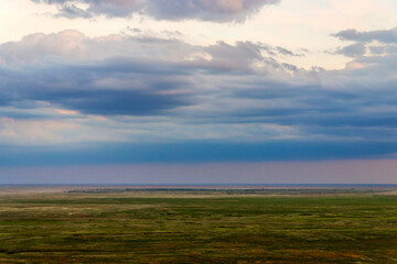 Fototapeta na wymiar Scenic sunset with clouds in sky in steppe