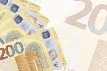 200 euro bills lies in stack on background of big semi-transparent banknote. Abstract business background
