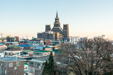 Obraz premium Aerial View of Suwon City of South Korea. A lots of traditional houses and modern buildings and The First Cathedral under the sunset.