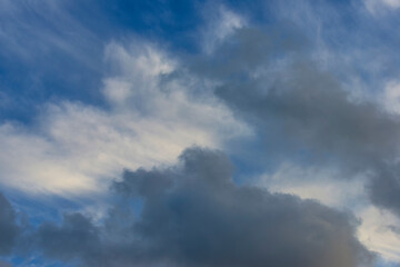 Naklejka na ściany i meble Grey white clouds in a blue sky in bright sunlight in autumn, Almere, Flevoland, The Netherlands, November 24, 2020