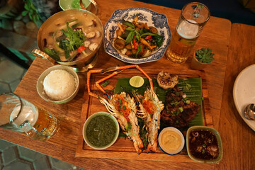 Grilled river prawn and barbecue beef steak, spicy soup and stir fry vegetables served with assorted dipping sauce and a glass of beer