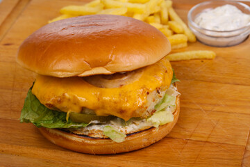 Homemade burger with fish, cheese and salad leaves