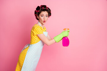 Profile side photo of shocked girl spray bottle copyspace wear yellow dotted dress rubber gloves isolated on pastel color background