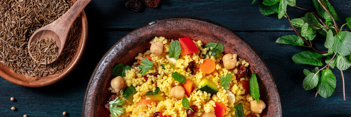 Couscous overhead flat lay panorama with ingredients on a dark wooden background
