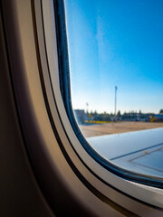 close up airplane window with airplane wing.