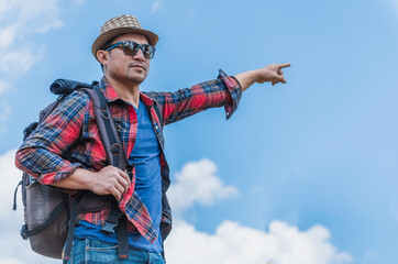 A young man traveler with backpack walking travel in the forest .lift to the sky.