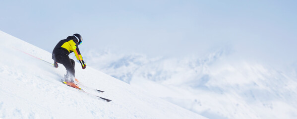 Skier skiing downhill in mountains